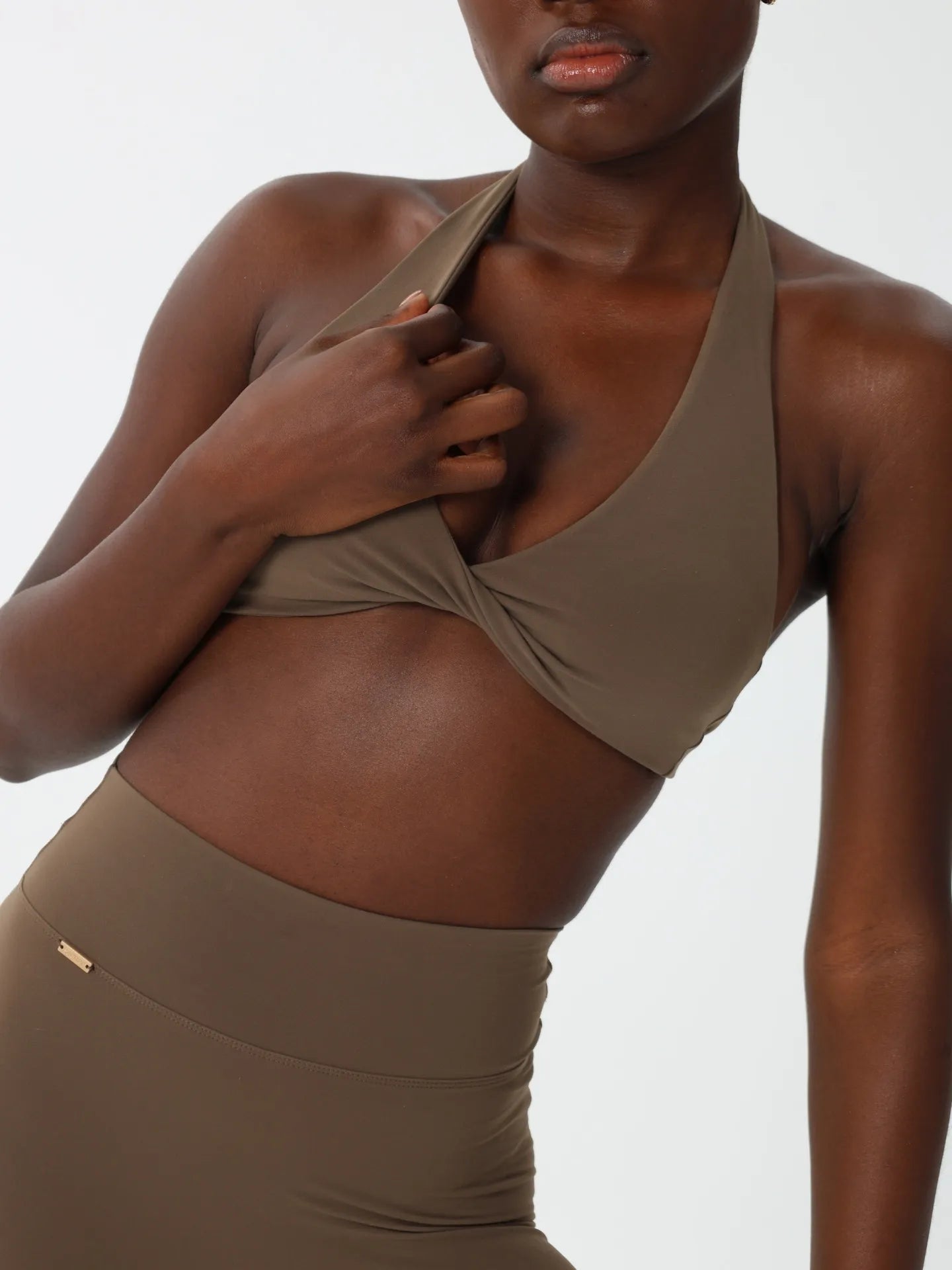 Olive halter bra highlighting sculpted fit.