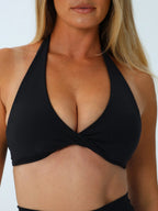 Model wearing the Origin Twist-Front Halter Bra in onyx during studio movement